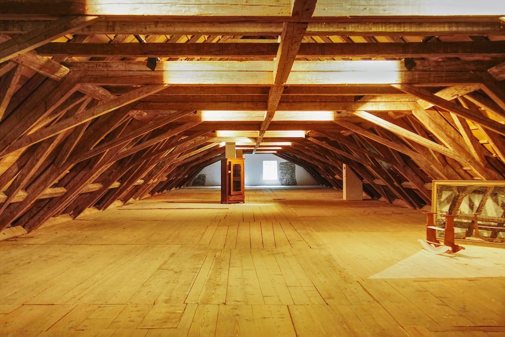 Une grande pièce avec parquet et poutres apparentes